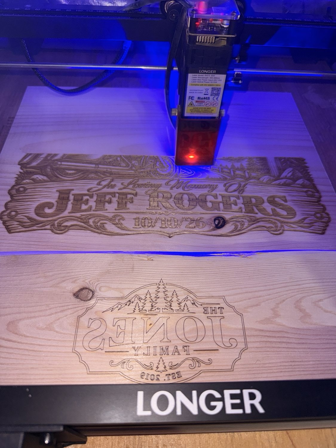 Laser engraver working on a wooden memorial sign